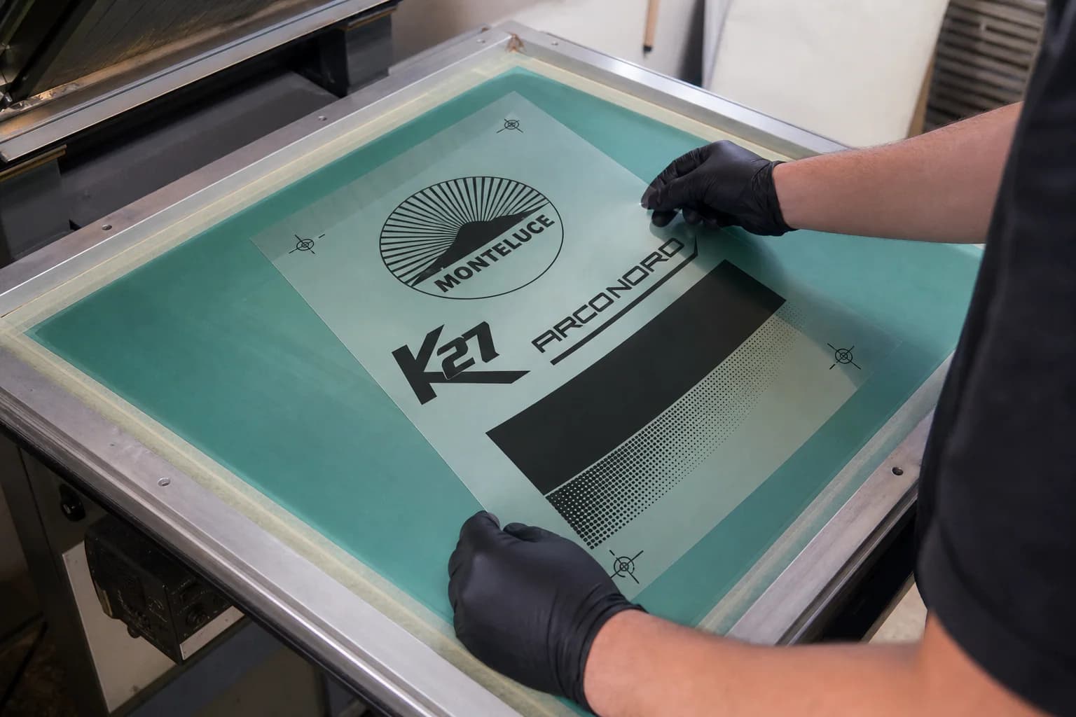 Tecnico che allinea una pellicola serigrafica sul telaio.